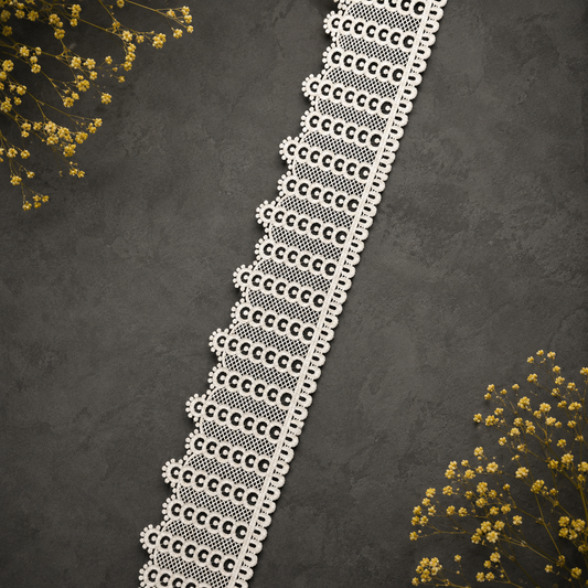 Decorative lace trim on a dark textured background with yellow flowers.