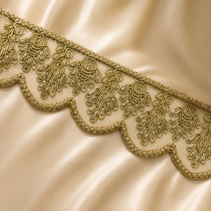 Close-up of gold lace trim on a beige fabric background