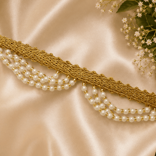 Pearl necklace with gold accents on a satin surface with flowers