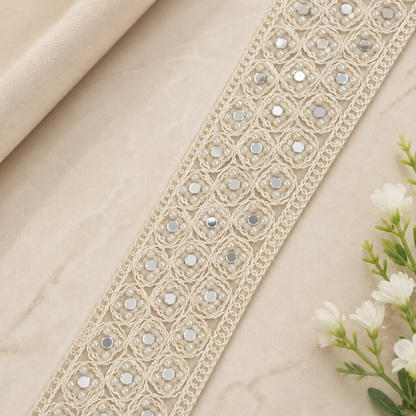 Decorative lace trim with beads on a beige fabric background